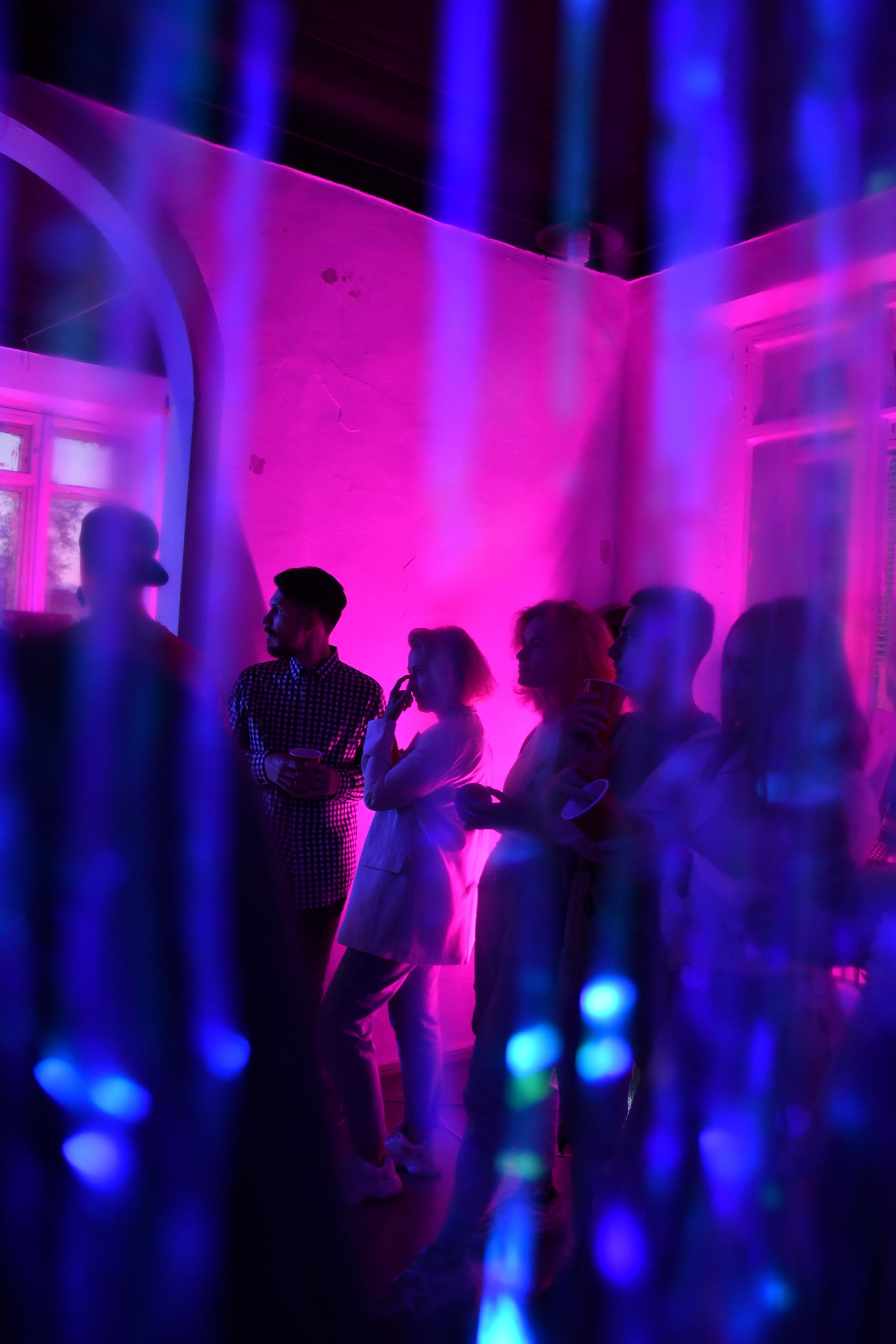 Friends at a house party under purple and pink light